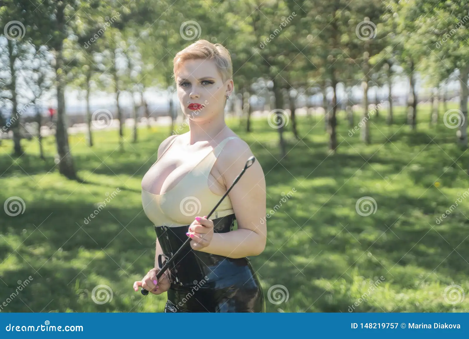 Hot Curvy Woman with Short Hair and Big Boobs Wearing Latex Kinky Secretary Dress with Feitsh Corset and Walking in the Park Alone Stock Image